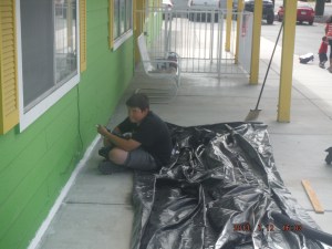 07-12 Here is Anthony putting the final touchs of paint on the seal up job at the pre school. and it was only 105 today, good thing we were in the shade